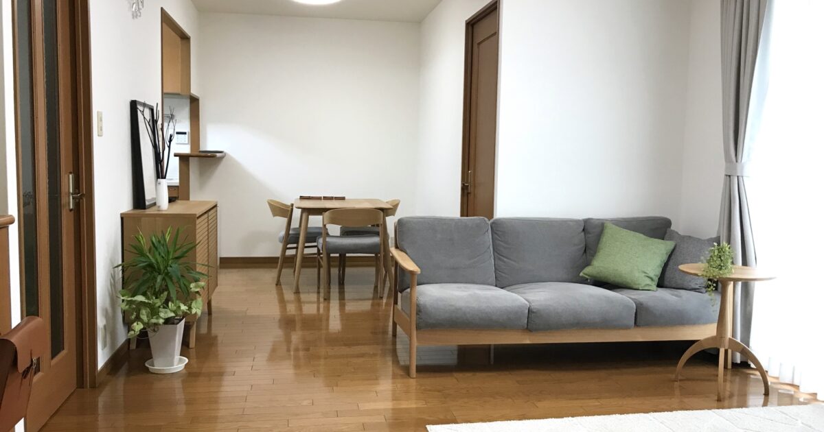 木製家具とグレーソファが調和するシンプルなリビングダイニング